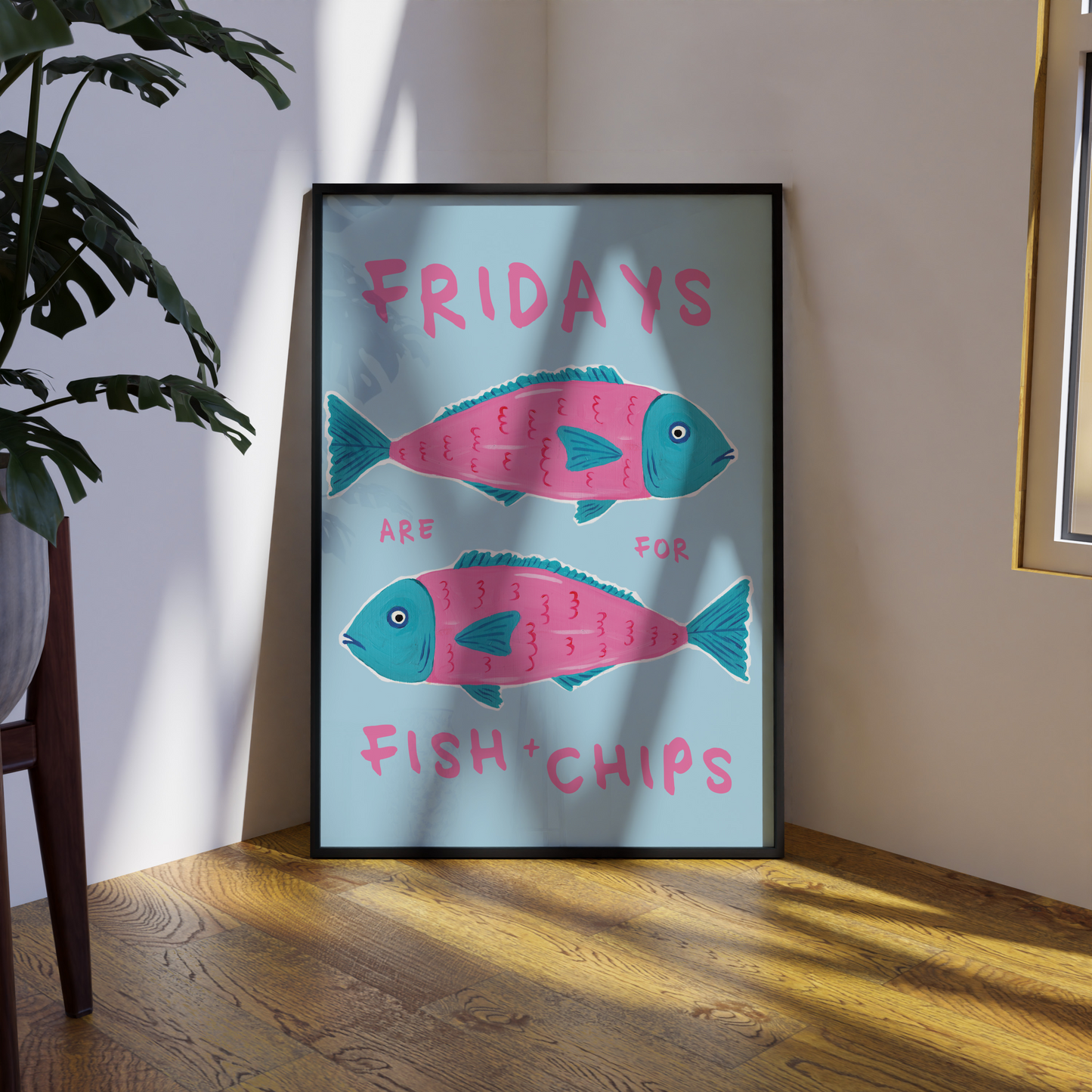 Framed artwork with fish and chips design on a wall.