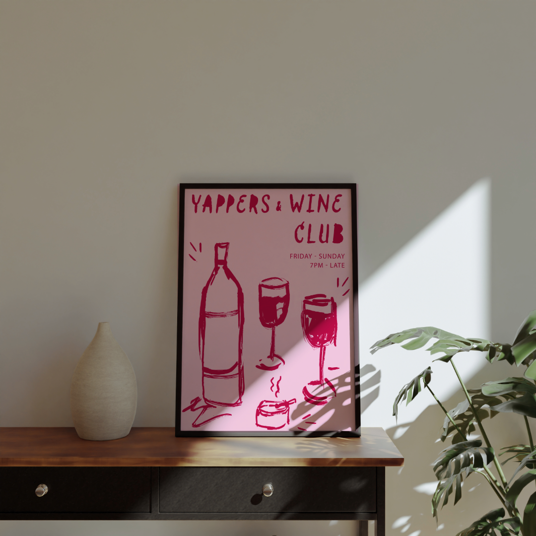 Yappers & Wine Club' on a wooden surface with a plant and vase in the background.